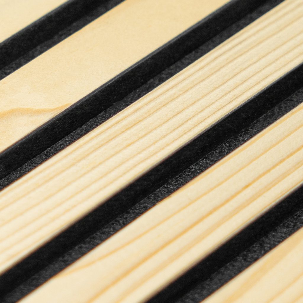 Close-up van een WoodUpp-product: lichtgekleurde, fijn geschaafde houten latten met zichtbare nerf, afgewisseld door zwarte rubberen antislipstrips. De foto toont de WoodUpp houten latten (slats) en de geïntegreerde zwarte profielstroken, onderdeel van hun elegante, functionele bureau- of opbergoplossing met matte afwerking en nauwkeurige pasvorm.