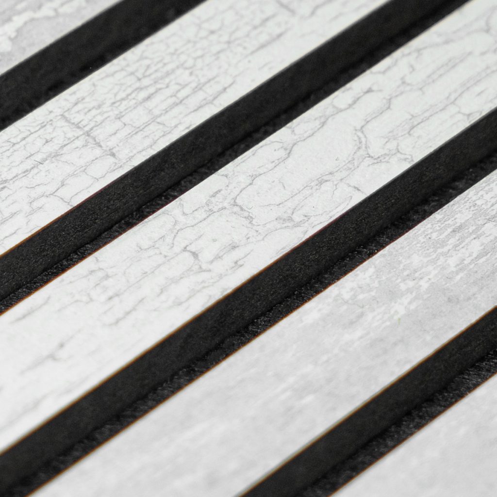 Close-up van WoodUpp-latten: diagonale lichtgekleurde latten met gebarsten, witte houtlook-toplaag en zichtbare nerven, afgewisseld met diepe zwarte tussenvoegen. Foto benadrukt de fijne textuur, het sterke contrast en de strakke lijnen van WoodUpp-latten voor gevels, terrassen of interieurbekleding en duurzame uitstraling.