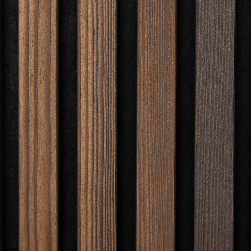 Close-up van vijf verticale WoodUpp houten lamellenpanelen met fijne groeven en zichtbare nerven, in variërende bruine tinten van warm lichtbruin tot donkergrijsbruin. Smalle zwarte tussenruimtes tonen contrast; de lamellen ogen matte, zorgvuldig gefineerd en geschikt voor wand- of akoestische afwerking.