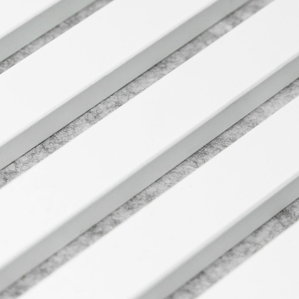 Close-up van een WoodUpp akoestisch lamellenpaneel: diagonale parallelle witte houten latten met daartussen zichtbare grijze akoestische viltvulling. Het beeld toont de strakke afwerking van de gelakte latten en de textuur van het geluidsabsorberende vilt achter de openingen in moderne, minimalistische stijl.