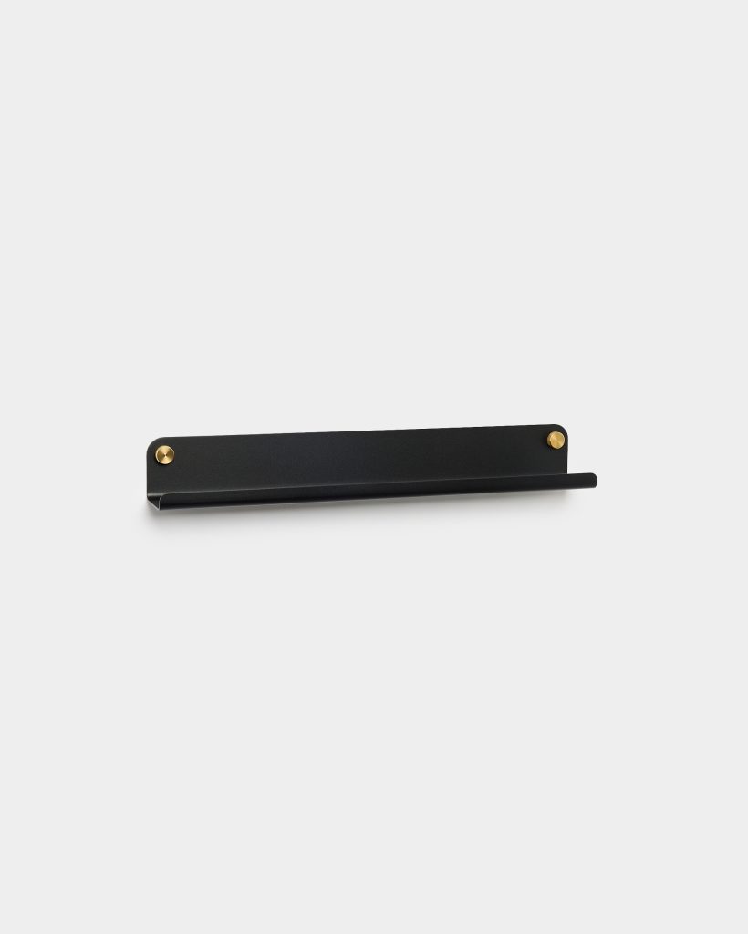 WoodUpp zwarte metalen wandplank met geïntegreerde smalle hangstang, strak design met afgeronde hoeken en twee goudkleurige bevestigingsknopen, gemonteerd op witte achtergrond. Functionele plank met lip aan voorzijde voor kleine items en strak minimalistisch profiel, ideaal als handdoek- of accessoirehouder voor dagelijks gebruik.