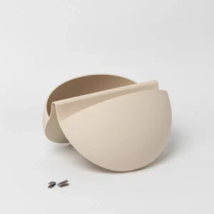 WoodUpp toont twee beige, halfronde matte wandplantenbakken met open bovenkant, licht in elkaar geschoven om vorm en diepte te accentueren. Voorin liggen twee kleine metalen ophangclips, bedoeld om deze slanke, moderne plantenpotten veilig en vlak tegen de muur te monteren.