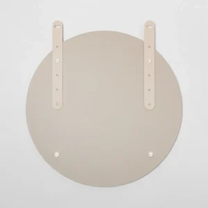 Achterkant van een WoodUpp ronde spiegel met twee verstelbare beige leren ophangriemen, bevestigd met metalen studs en schroefpunten op een matte zandkleurige achterplaat. Minimalistisch, strak afgewerkt ontwerp; zichtbare uitsparingen en subtiel gegraveerd WoodUpp-logo op één riem. Met meerdere verstelgaten en ronde metalen sluitingen, geschikt voor wandmontage in neutrale, moderne interieurs.